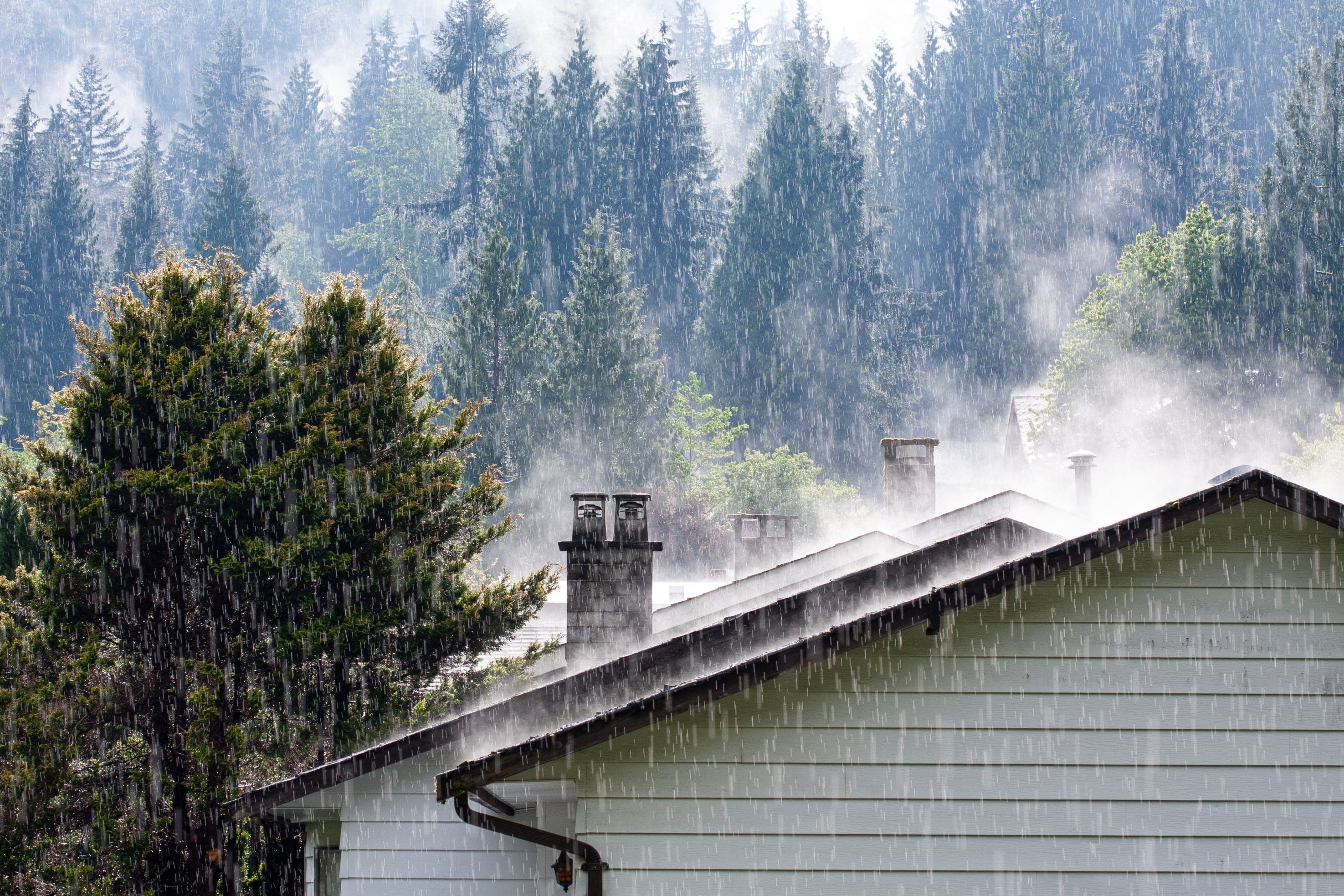 Heavy rain falling on a home with masonry chimneys in the Pacific Northwest.